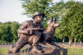 Beautiful, shiny memorial of the soldier, with the dog, in Neillsville, Wisconsin, USA, among the colorful plants