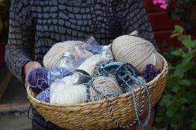 everything for knitting in a wicker basket in hands