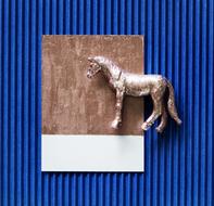 horse figurine at striped blue background