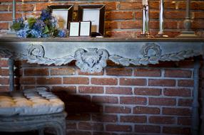 decorative table and chair against a brick wall