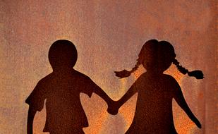 silhouettes of a boy and a girl on the wall