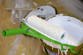Roller on bucket with white Paint