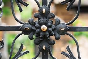 gilded rose on the wrought iron grate of the cemetery