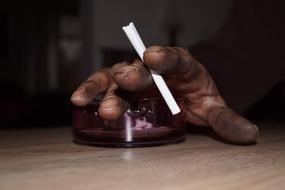 cigarette in the dirty hand of a worker