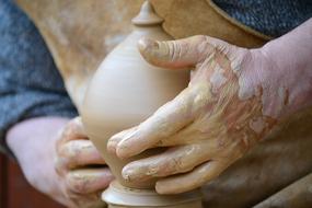 man makes an object out of clay