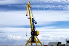 yellow port crane on a background of clouds