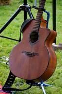 guitar on a stand on a lawn in a park
