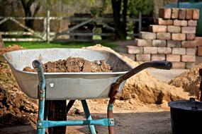 wheelbarrow with trash on brick yard