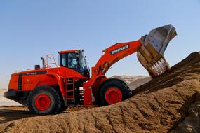 red bulldozer is pouring sand