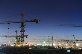 Engineering mechanical cranes in the city with colorful lights