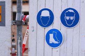 blue signs on white wooden wall