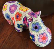 Beautiful and colorful Happypotamus made with Crochet on the wooden surface