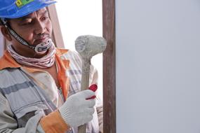 Worker with wooden hammer in doorway