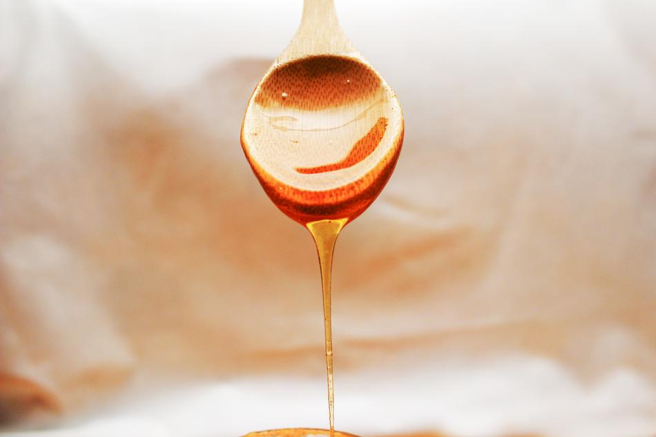 Honey Flowing on wooden Spoon