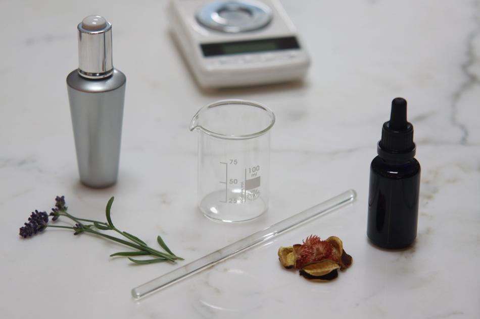 beaker, pipette, perfume on the white table
