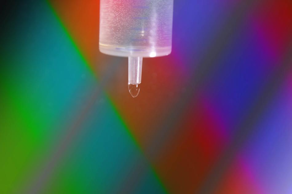 water in a syringe on a colored background