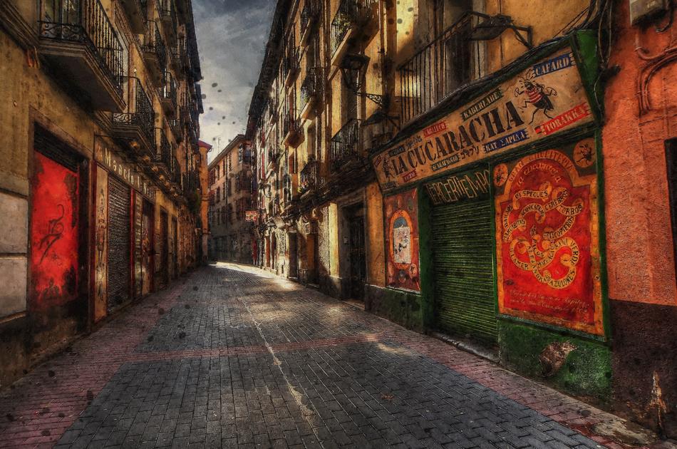 Beautiful and colorful street, with the pavement, in Spain, under the cloudy sky