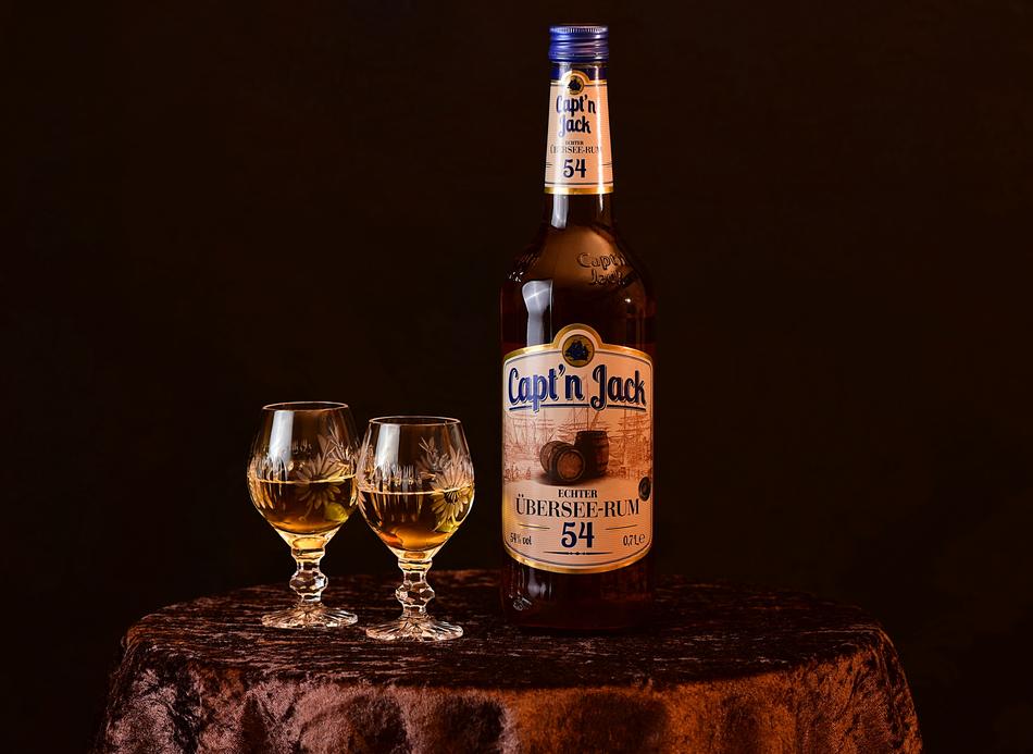 a bottle of alcoholic drink next to a couple of glasses