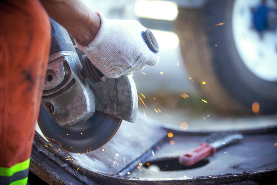 Worker with the gloves, working with the tools, with sparks