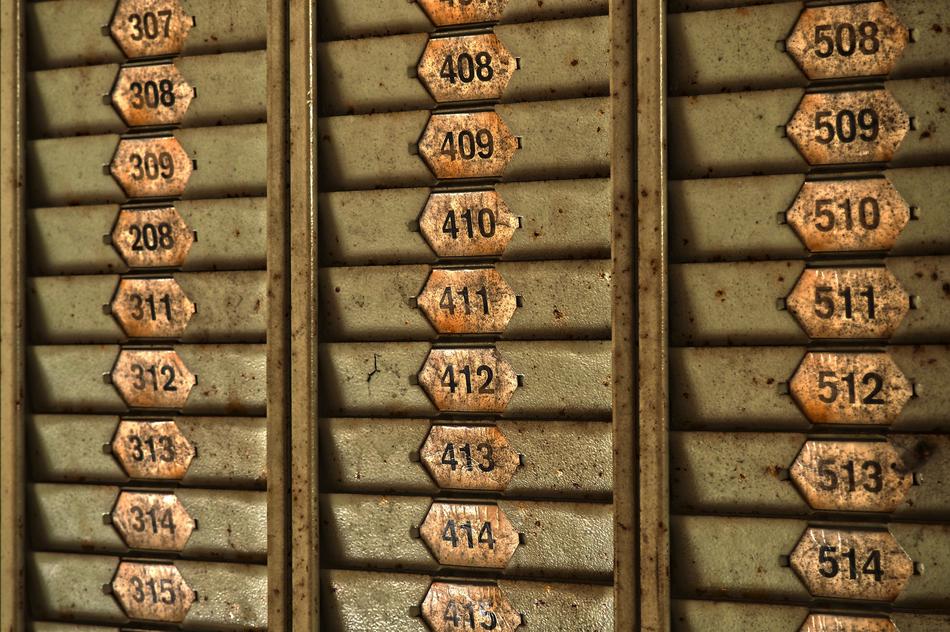 Old, rusty mail boxes with metal numbers