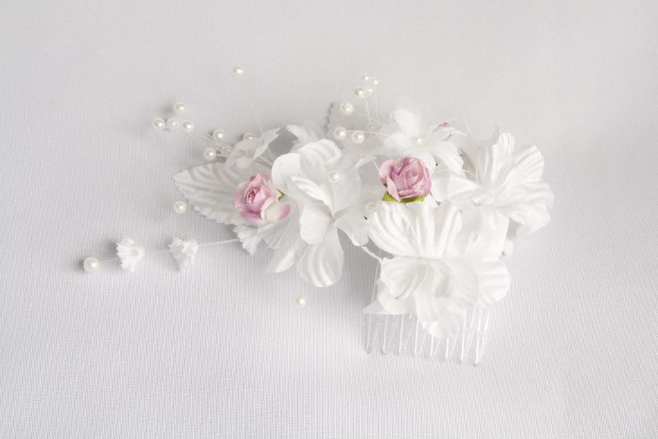 Beautiful, white and pink flowers and transparent comb, on the white surface