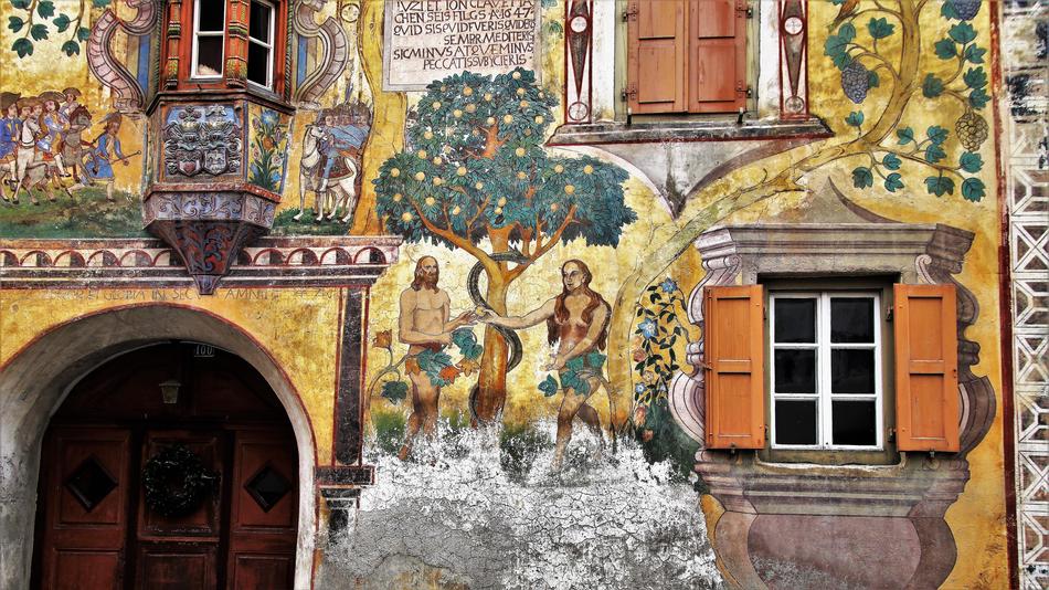 Adam And Eve in paradise, aged fresco on facade of historical building