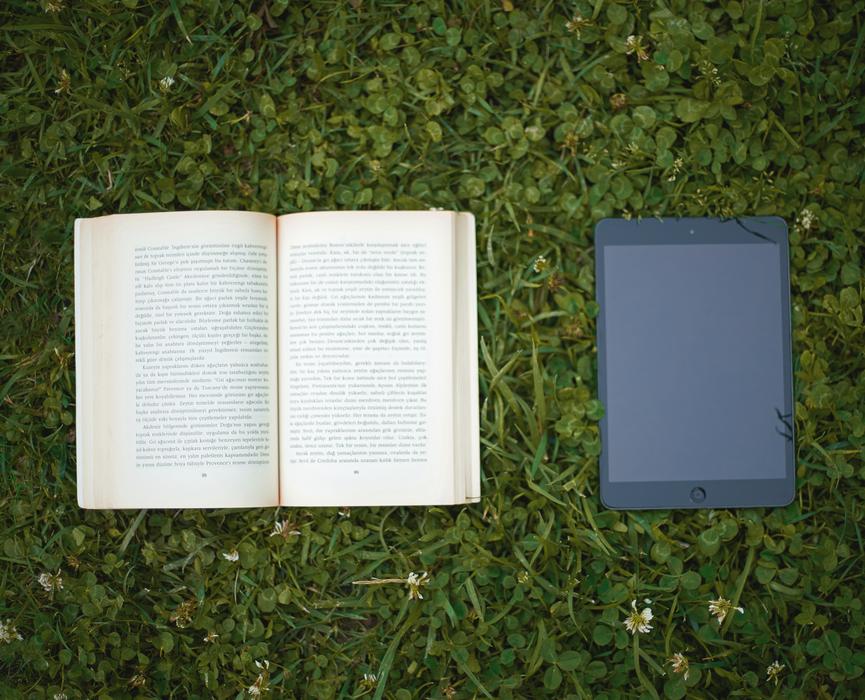 open book and tablet are on the lawn