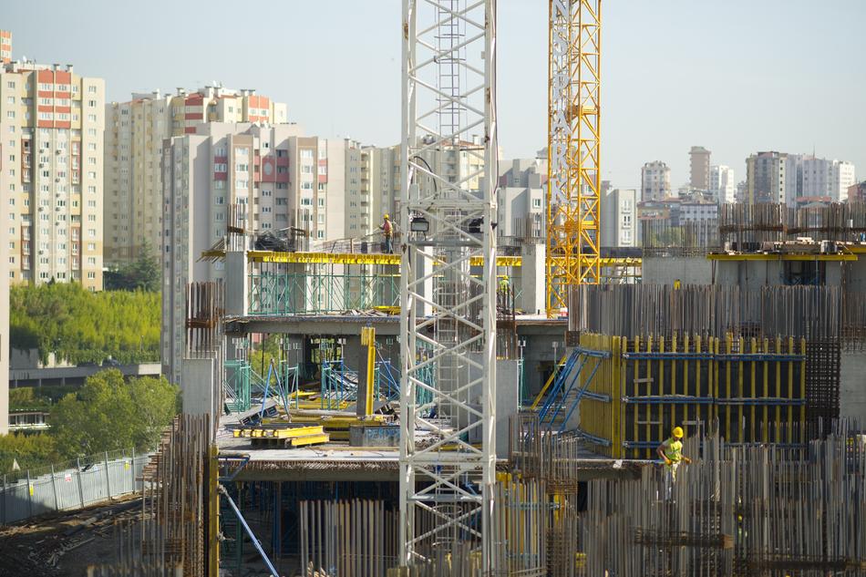 Workers on the new construction, among the city and plants