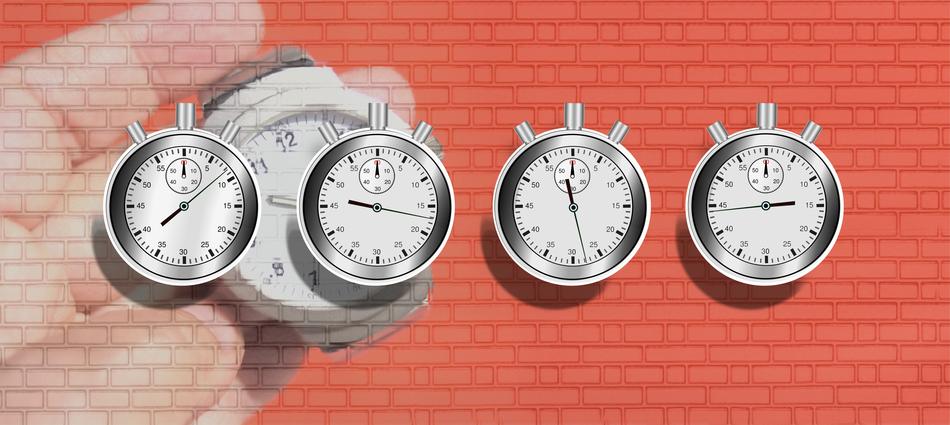 stopwatch in hand at brick background