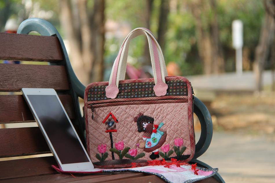 women bag and tablet on the bench