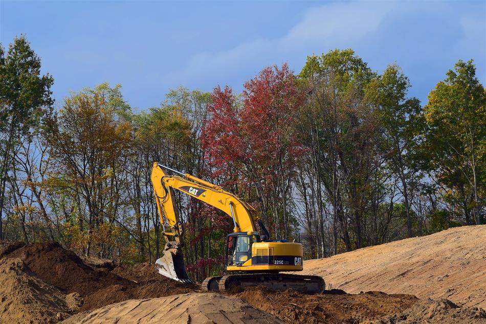 Yellow machine on the construction among the colorful plants