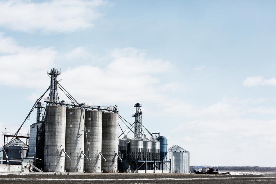 Construction with the gas folders, on the landscape, under the blue sky with white clouds