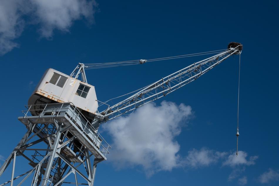 harbor crane on the background of the sky with white clouds