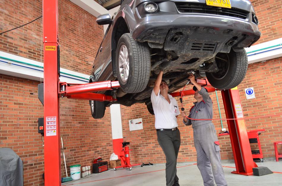 auto mechanic shows customer a car breakdown