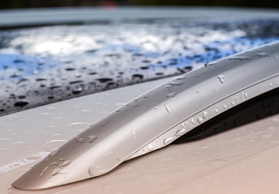 Close-up of the railing of an auto in water drops and light