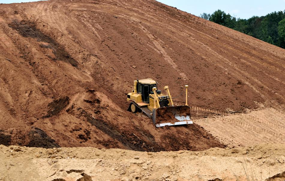 Bulldozer on side of hill near the plants