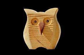 wooden owl on black background