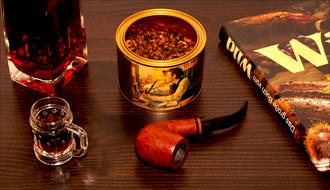 tobacco, smoking pipe and brandy on the table