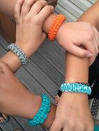female Hands with colorful Bracelets holding in Square