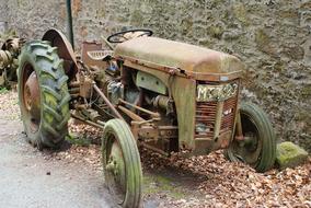 Old abandoned Tractor at stone wall