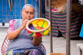 woman painting wooden bowl