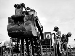 Black and white photo of the workers with excavators