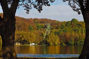 photo of a tower on the shore of an autumn lake