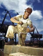 adult man working with vintage hand drill on construction site