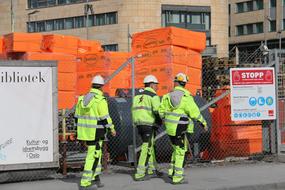 workers in uniform and helmets at a construction site