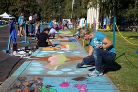 artists draw with chalk on the pavement