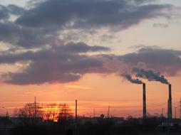 Pollution of environment, smoking chimneys of Factory at evening sky