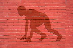 Shadow of a person, preparing to run, on the red wall, clipart