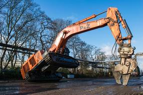 Excavator demolits asphalt with scissors