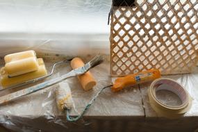 rollers, brush and tape on the windowsill